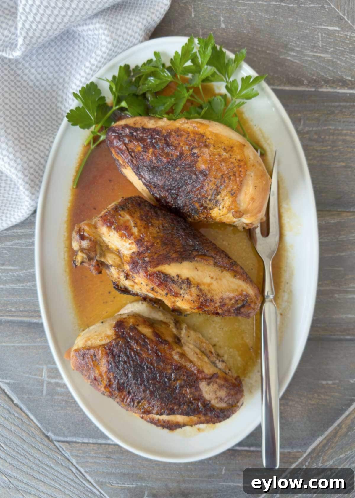 Perfectly Roasted Chicken Breasts 2 Golden baked bone-in chicken breasts on a platter with pan juices, ready to serve.