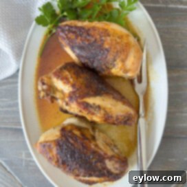 Golden baked chicken breasts on the dinner table, garnished for serving.