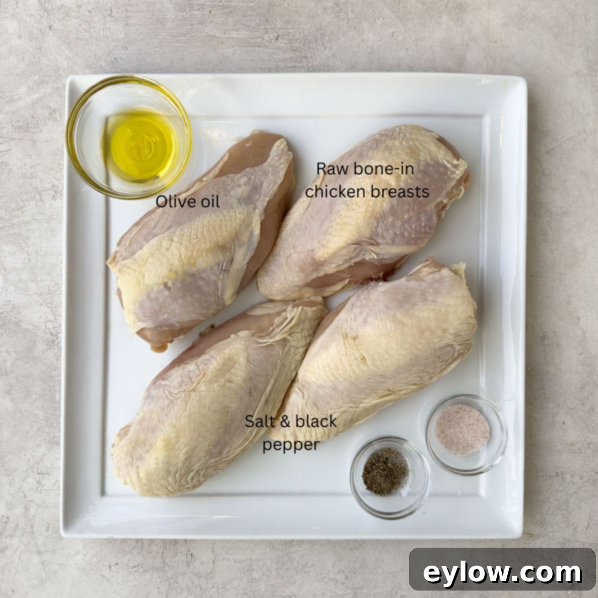 Perfectly Roasted Chicken Breasts 3 Raw bone-in chicken breasts on a white platter, ready for seasoning.