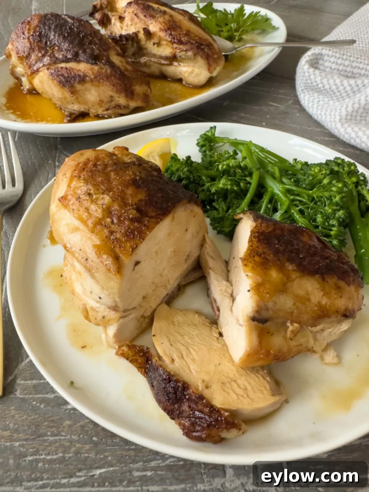 Perfectly Roasted Chicken Breasts 6 Roast chicken breast on plate, sliced to eat, with broccolini and pan juices.