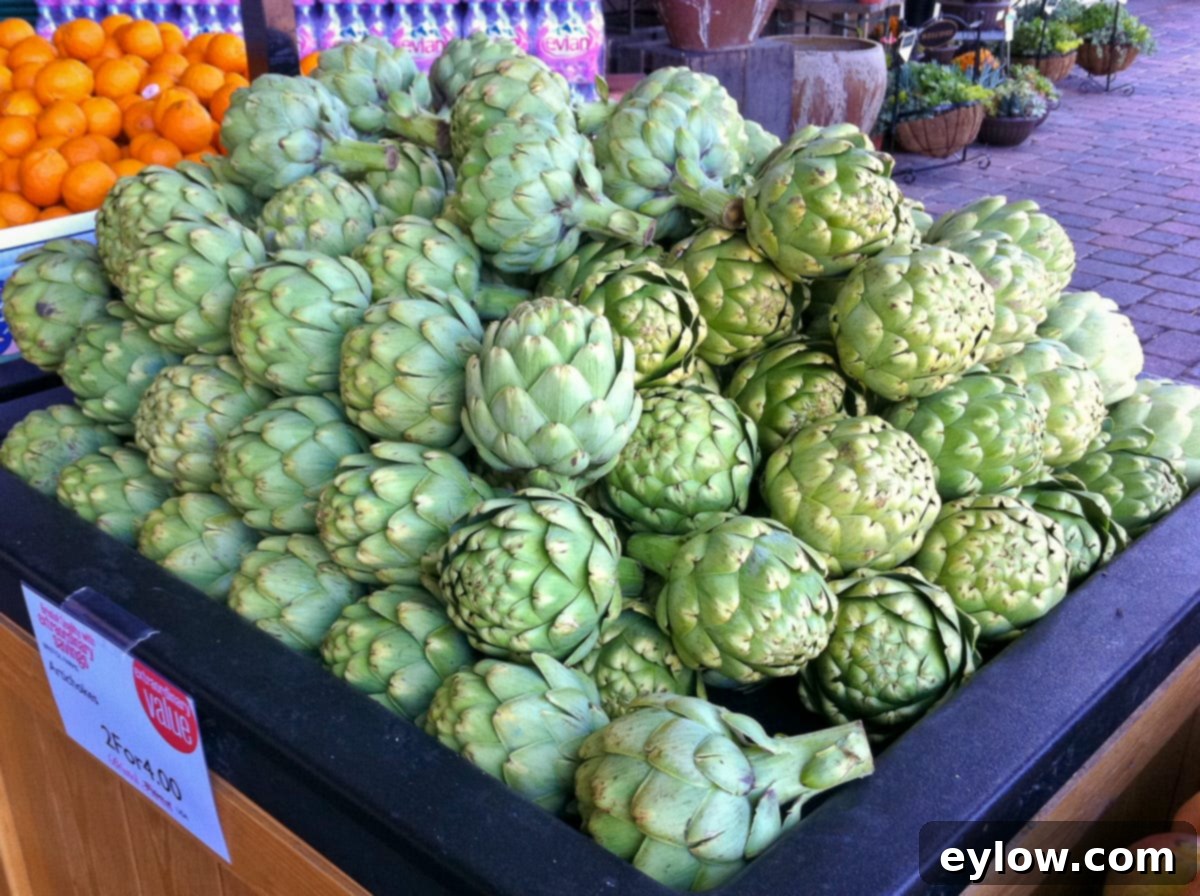 A vibrant display of fresh, compact artichokes at a grocery store