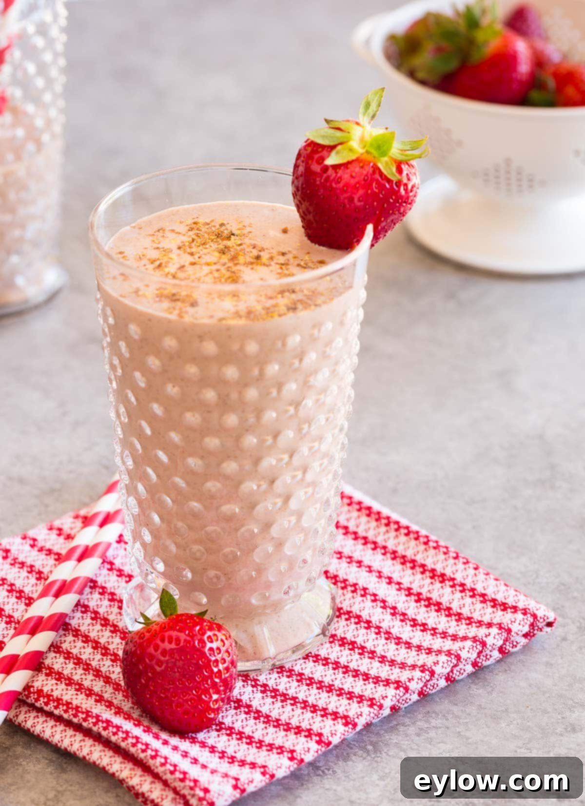 Creamy Strawberry Banana Yogurt Blend 2 A glass of strawberry banana yogurt smoothie topped with a fresh red strawberry.