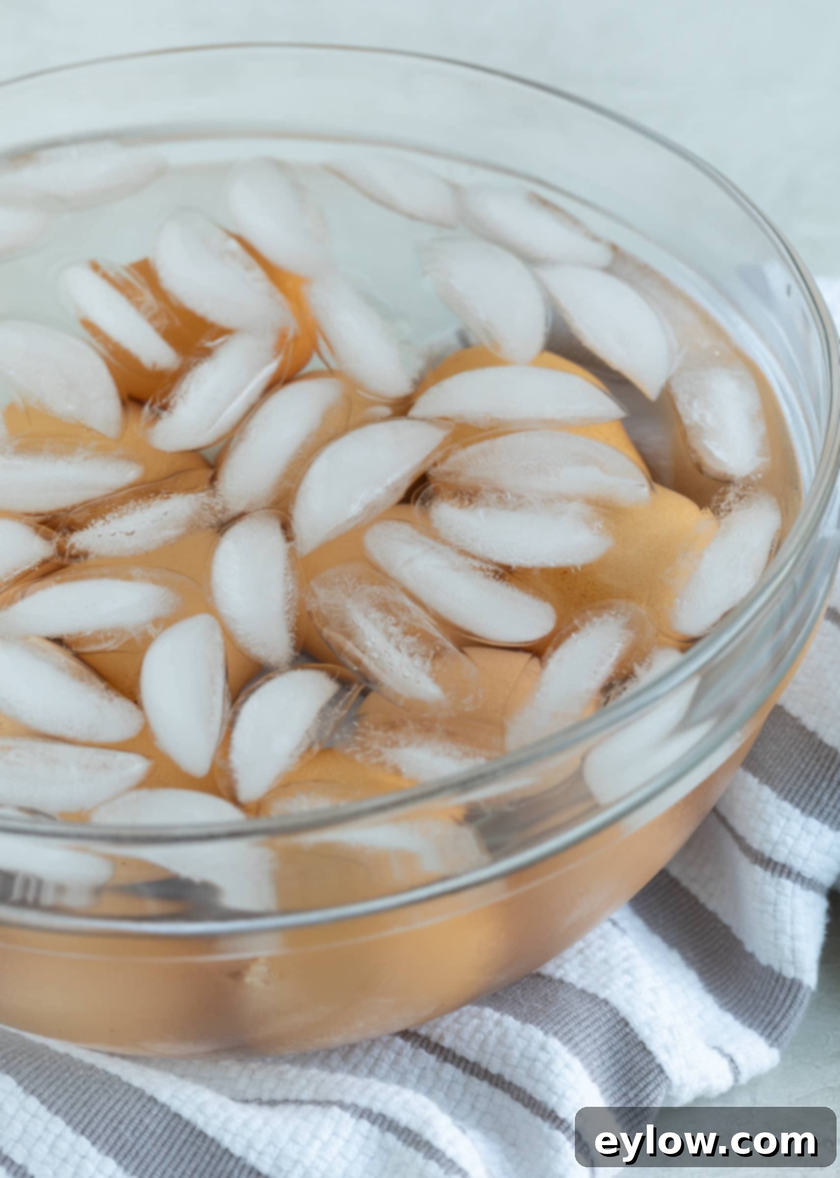The Ultimate Deviled Eggs 3 A glass bowl with ice cubes and water chilling down hard boiled eggs in an ice bath after boiling.