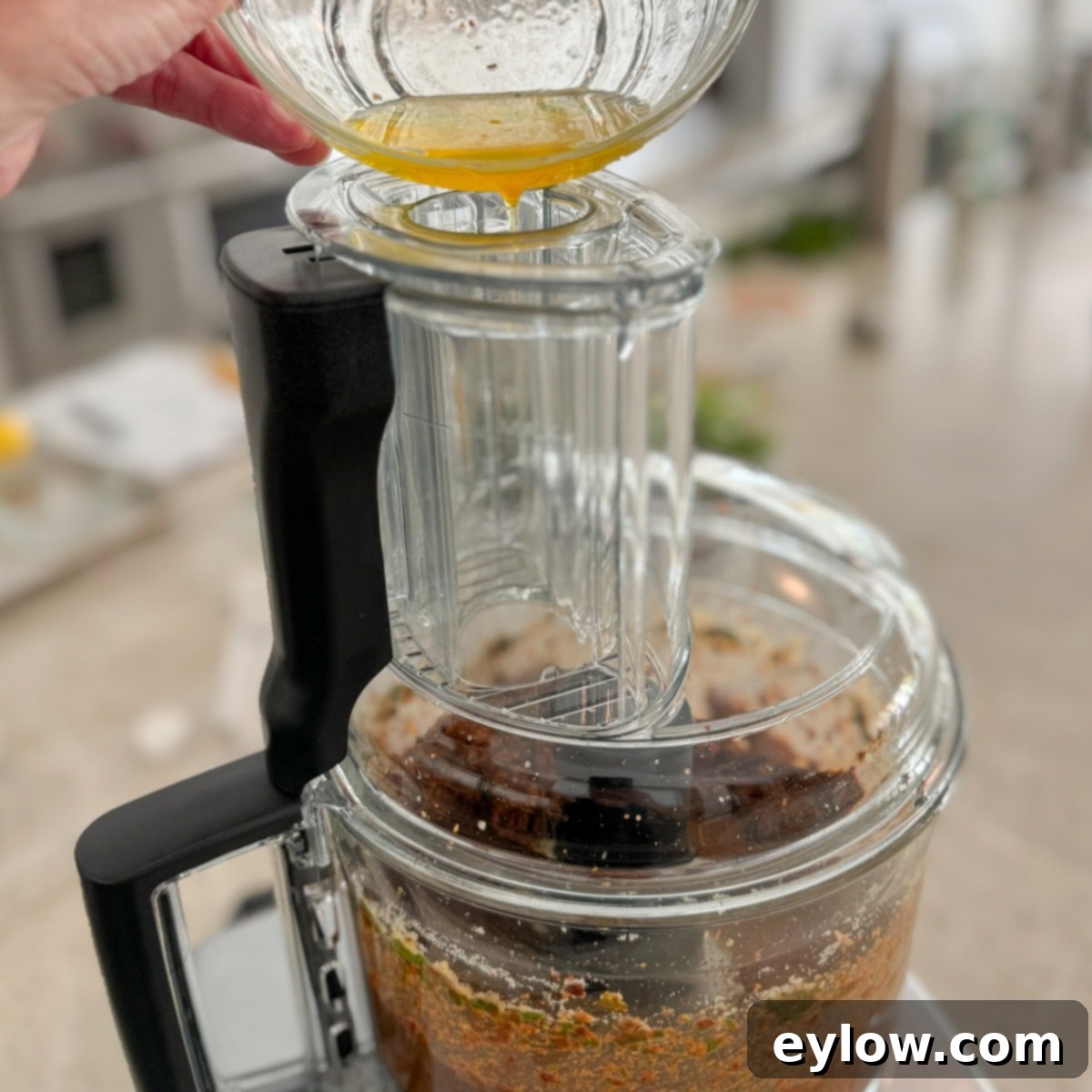 Crimson Sun Pesto 6 Drizzling olive oil into a food processor through the feed tube.