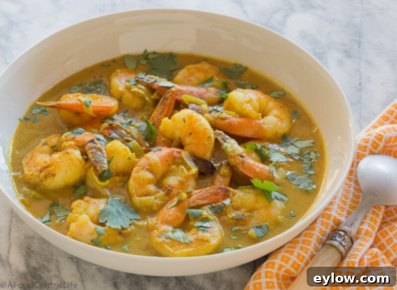 Effortless Coconut Shrimp Curry 4 Close-up of creamy coconut shrimp with curry in a pan, steaming gently.
