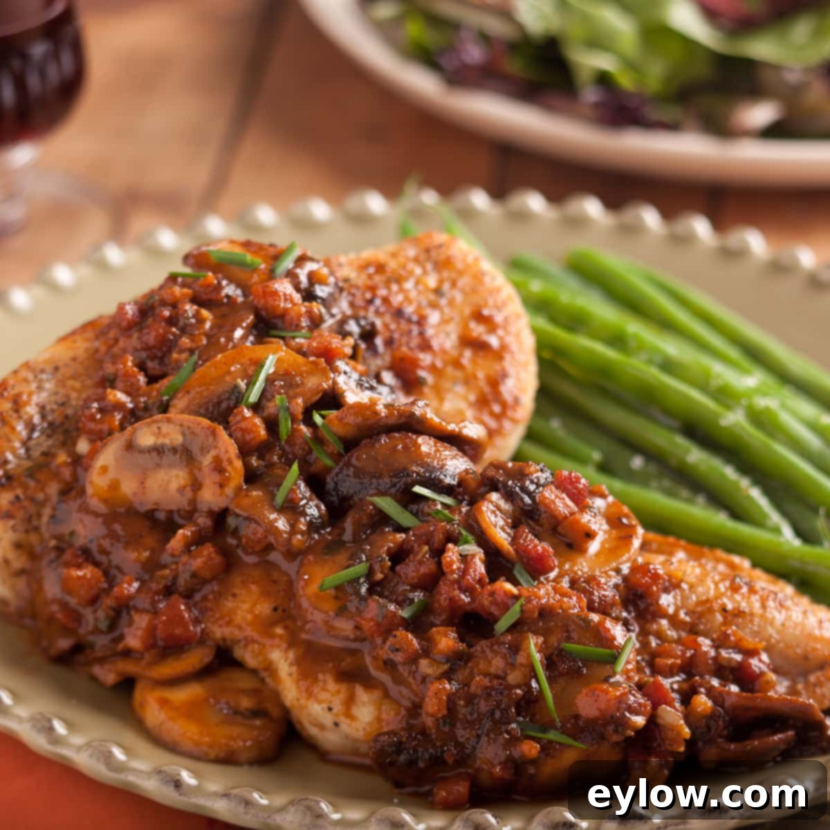 A full plate of Chicken Marsala, garnished with fresh herbs, alongside perfectly cooked green beans, ready for a delicious dinner.