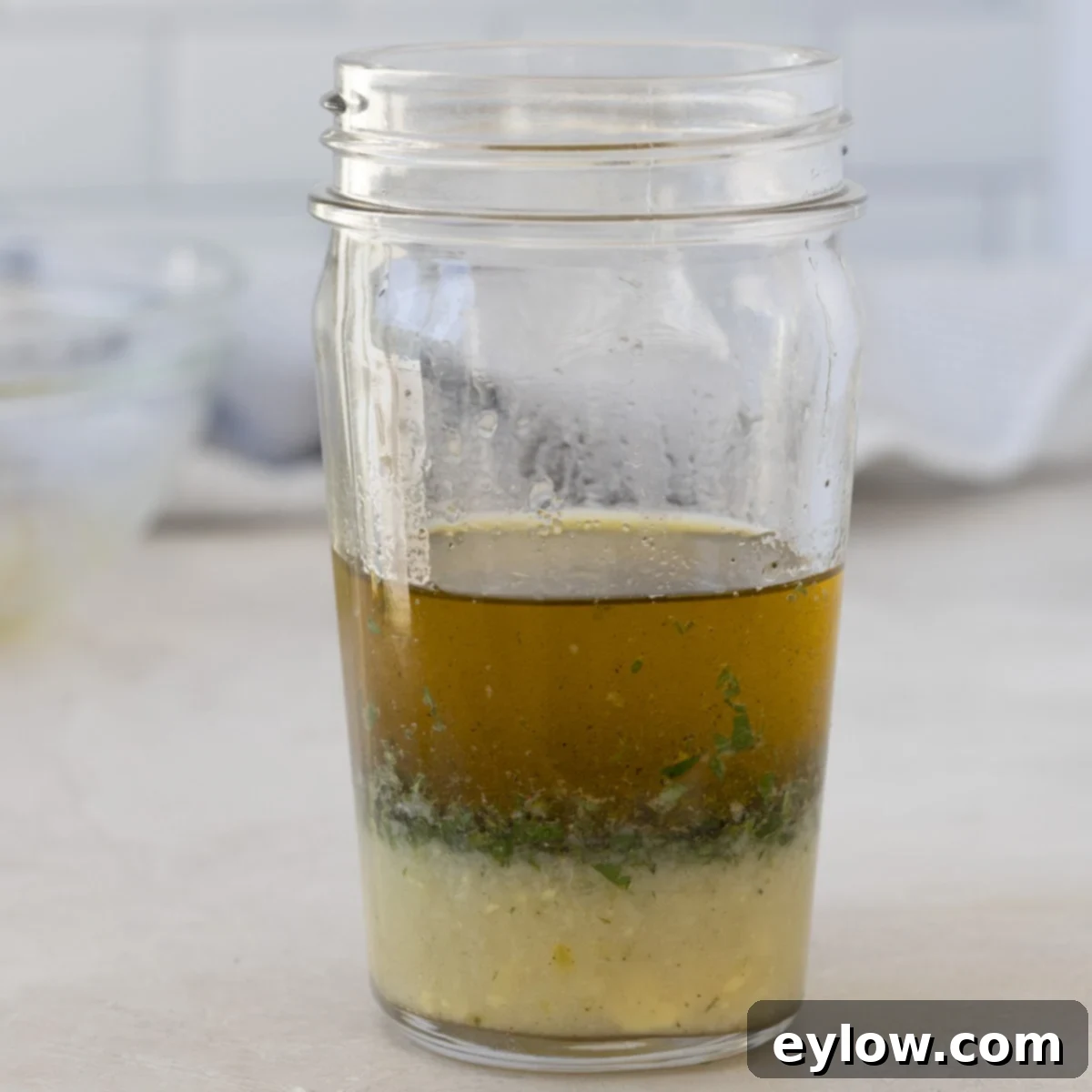 Lemon vinaigrette ingredients in a jar, not blended. 