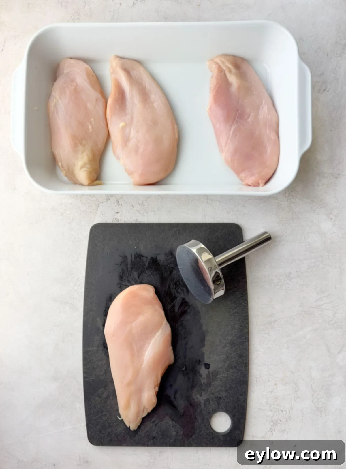Raw boneless skinless chicken breasts in a casserole dish.