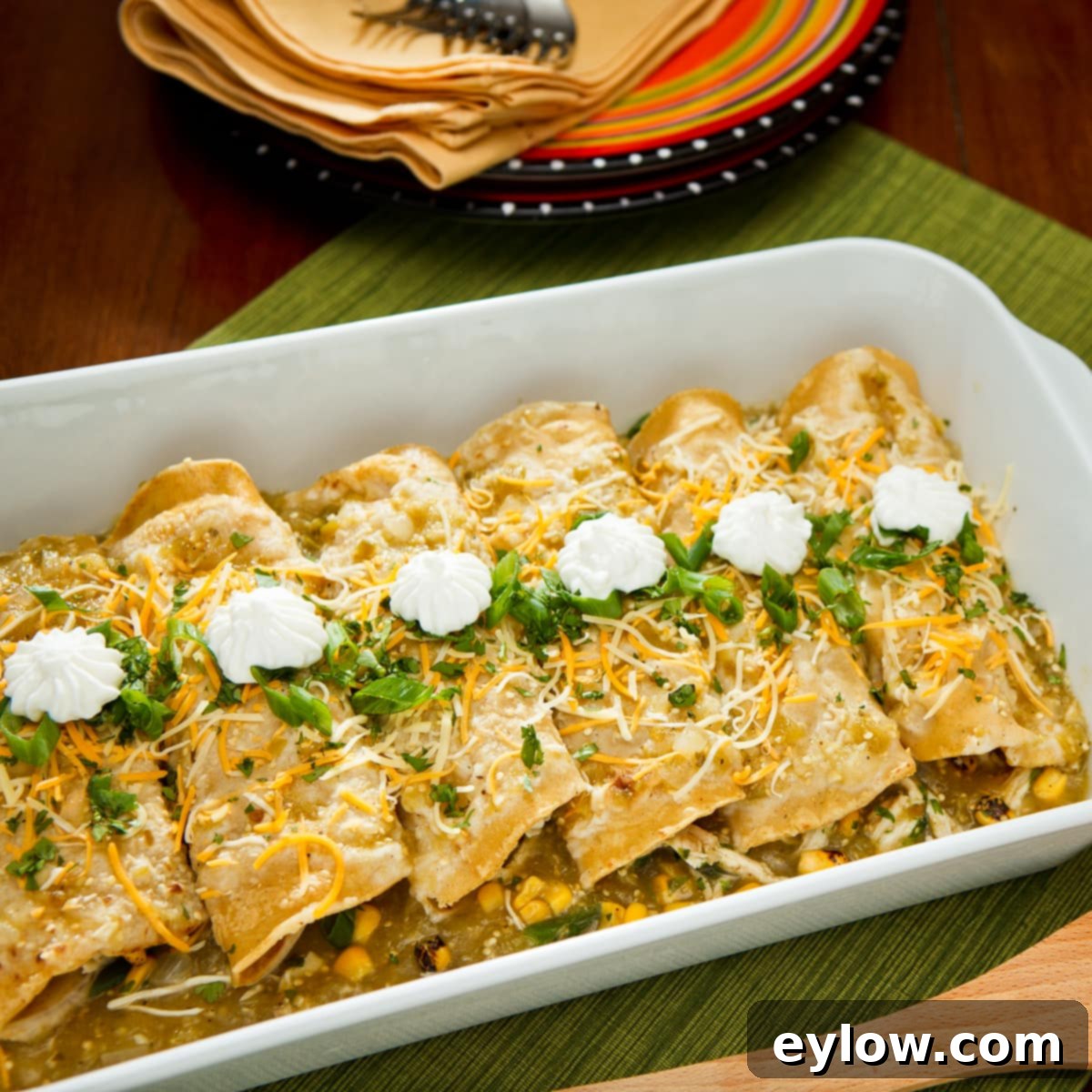 Zesty Roast Chicken Verde Enchiladas 2 Chicken enchiladas with vibrant green tomatillo sauce, garnished with fresh cilantro, in a rustic casserole dish, ready to be served.
