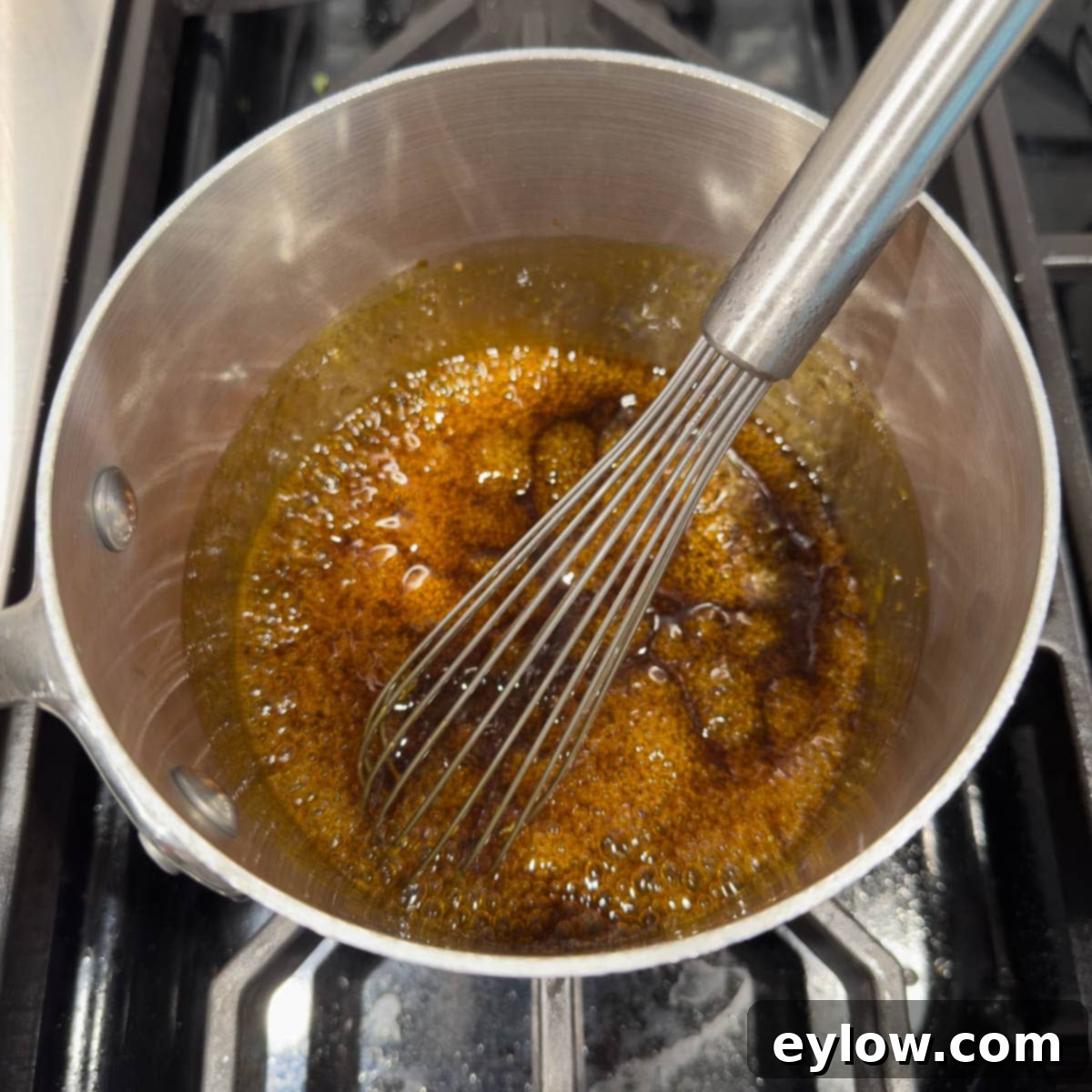 Teriyaki sauce at a simmer for thickening the sauce.