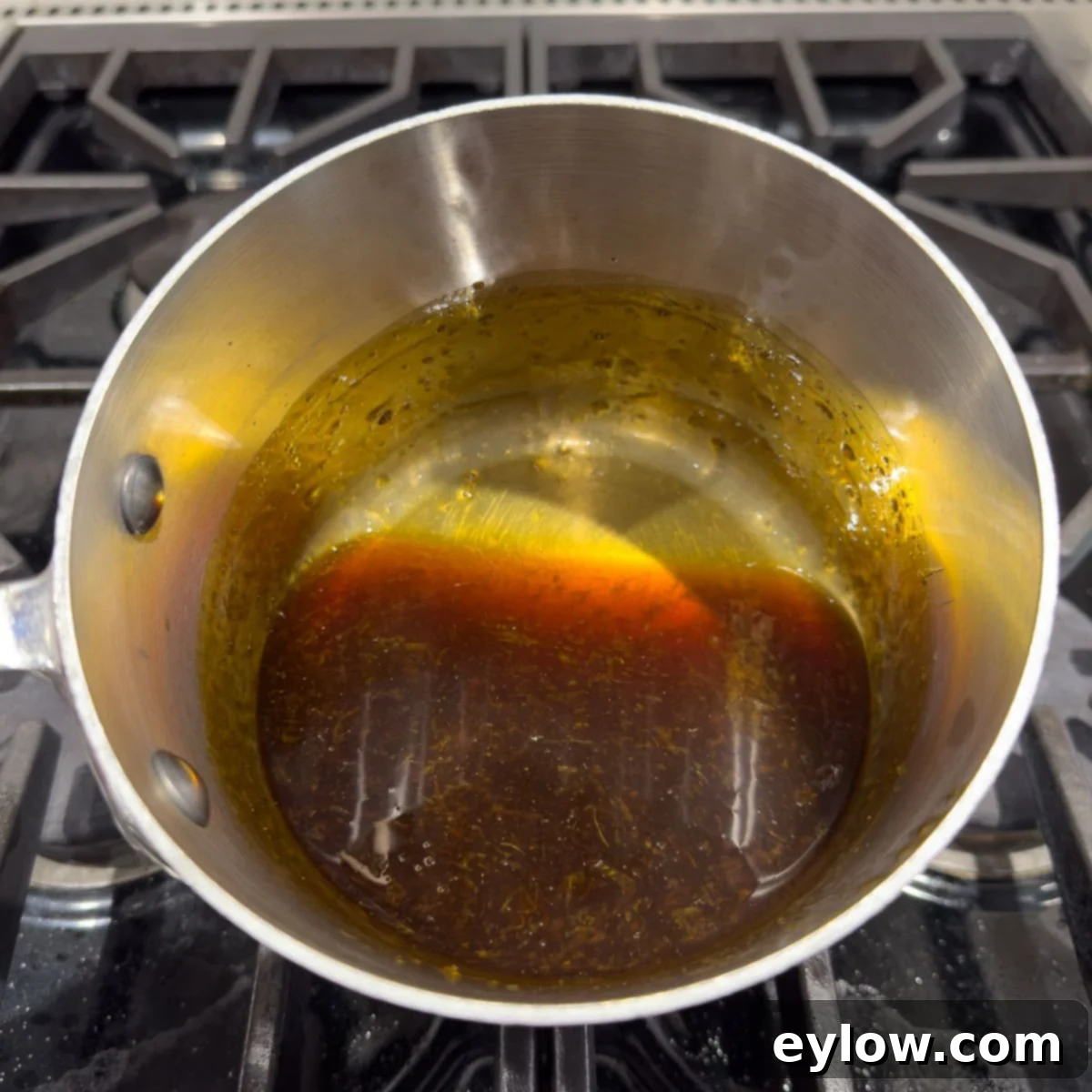 Thickened teriyaki sauce in a small pan on the stove before straining.
