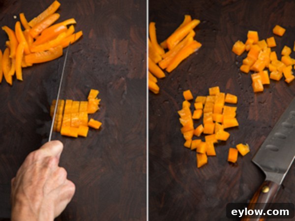 Dicing bell pepper strips into small, even pieces.