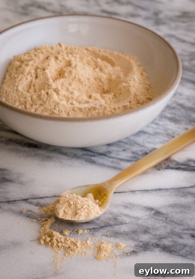 Velvet Chocolate Banana Dream 4 Maca powder in a bowl and spoon on a marble surface, highlighting the adaptogen ingredient.