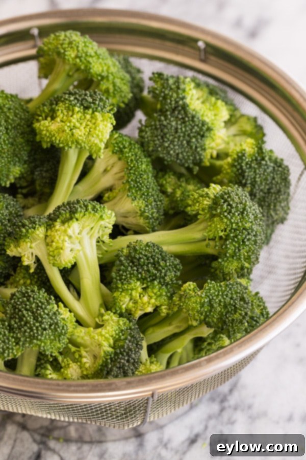Cleaned green broccoli florets in a colander