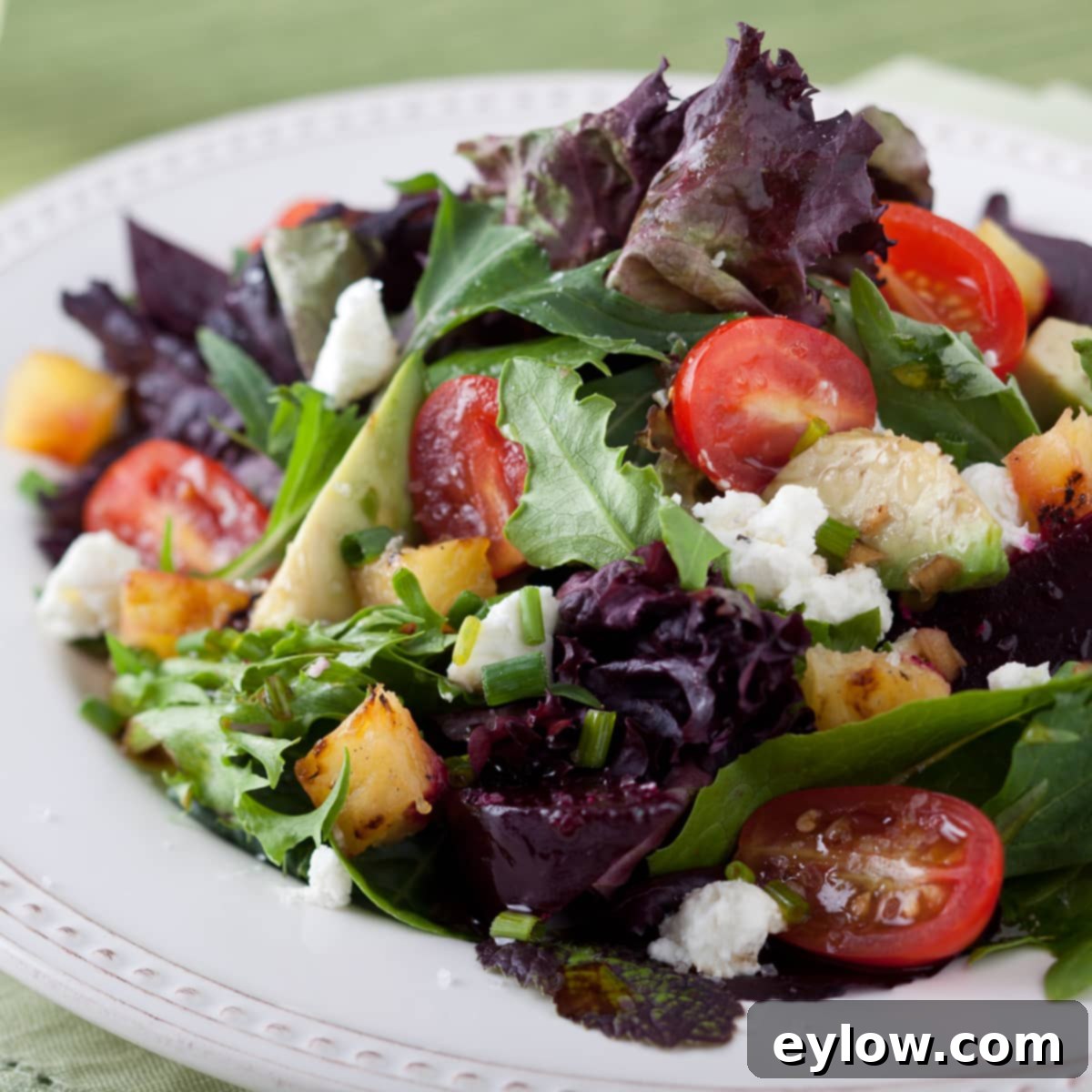 Hawaiian Goat Cheese Salad 6 A beautifully arranged colorful Hawaiian salad featuring fresh greens, sweet pineapple, ripe tomatoes, earthy beets, and creamy goat cheese, served in an elegant white bowl.