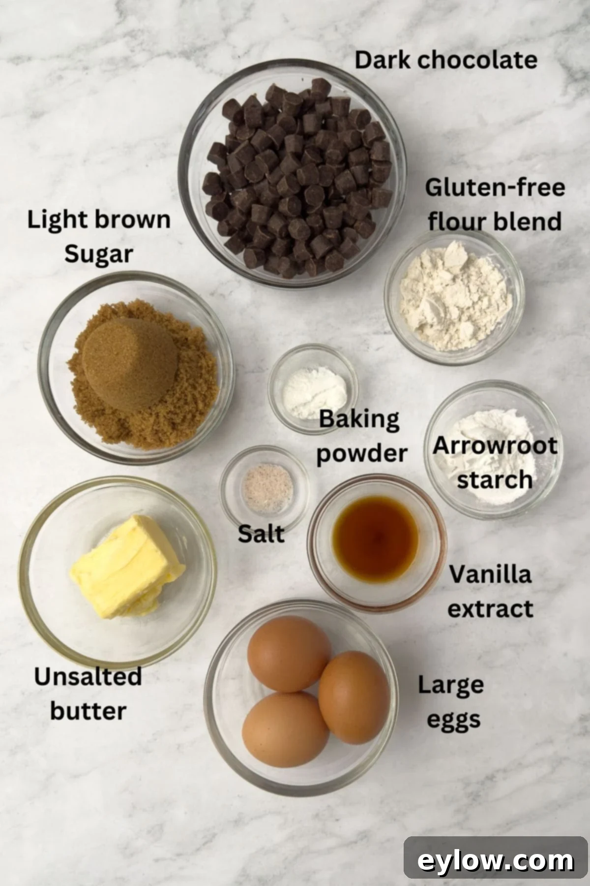 Decadent Fudgy Gluten-Free Chocolate Brownies 3 Ingredients for gluten-free brownies laid out on a counter in glass bowls, including chocolate, butter, sugar, and flour.