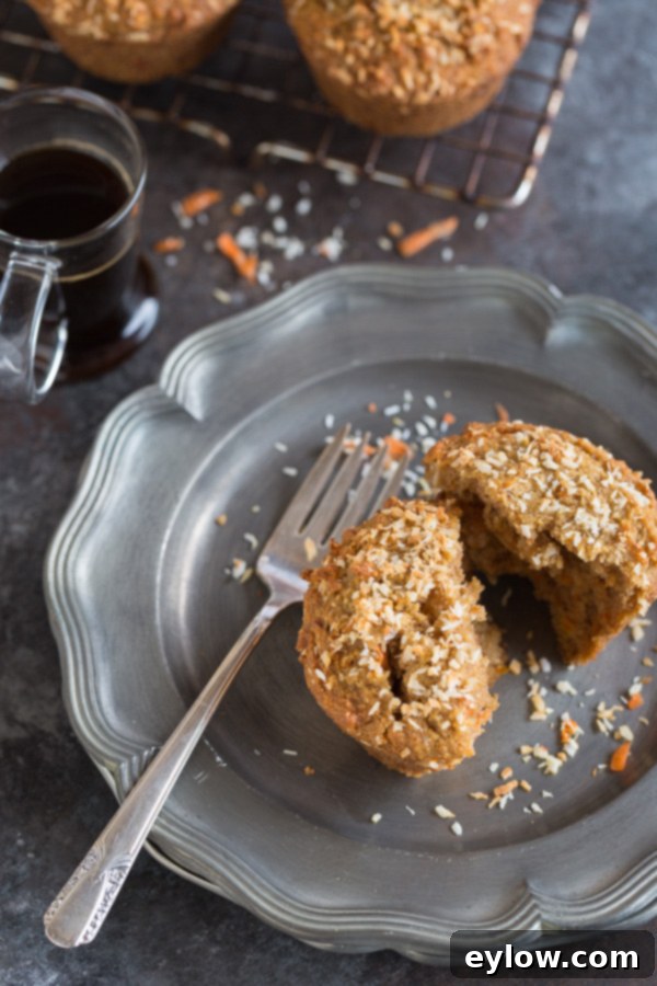 Moist Gluten-Free Dairy-Free Carrot Cake Muffins 2 A perfectly baked, fluffy gluten-free carrot cake muffin on a silver plate, showcasing its golden-brown top and moist texture.