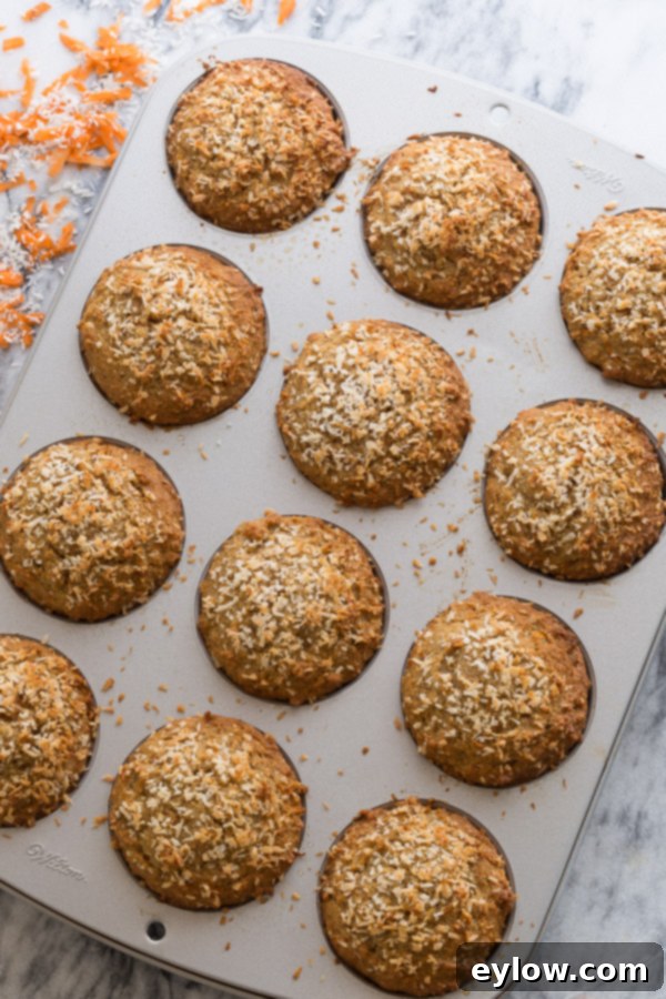 Moist Gluten-Free Dairy-Free Carrot Cake Muffins 4 A batch of freshly baked gluten-free carrot cake muffins, golden-brown and cooling on a wire rack.