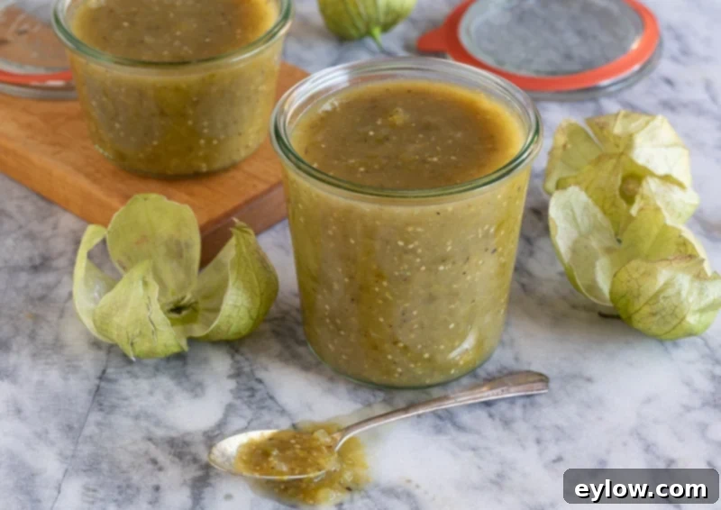 Tomatillo Enchilada Verde 7 Glass jars filled with homemade tomatillo sauce, some ready for freezing.