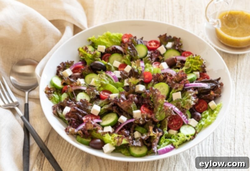 Classic Greek Garden Salad 3 Close-up of a vibrant Leafy Green Greek Salad in a large bowl, showing the fresh textures of lettuce, cucumber, tomato, feta, and Kalamata olives.