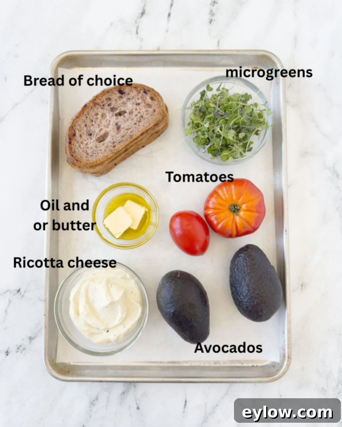 Vibrant Tomato Avocado Toast 3 Assorted ingredients for tomato avocado toast including bread, tomatoes, avocado, ricotta, and microgreens.