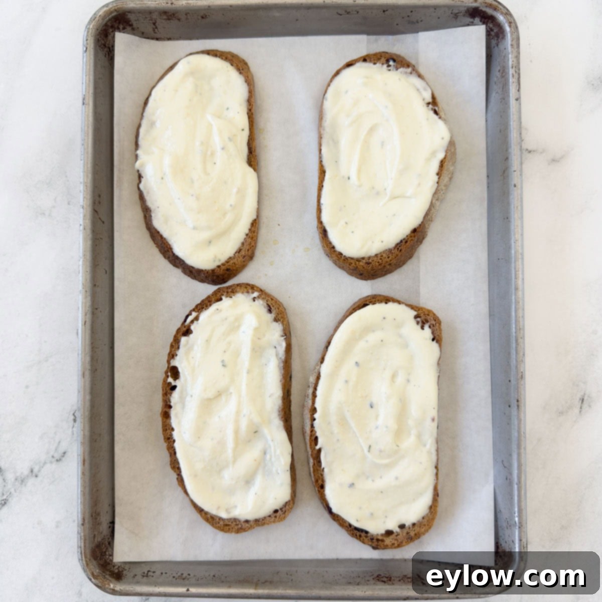 Vibrant Tomato Avocado Toast 5 Toasted bread spread with creamy ricotta cheese, ready for the next layer of tomato and avocado.