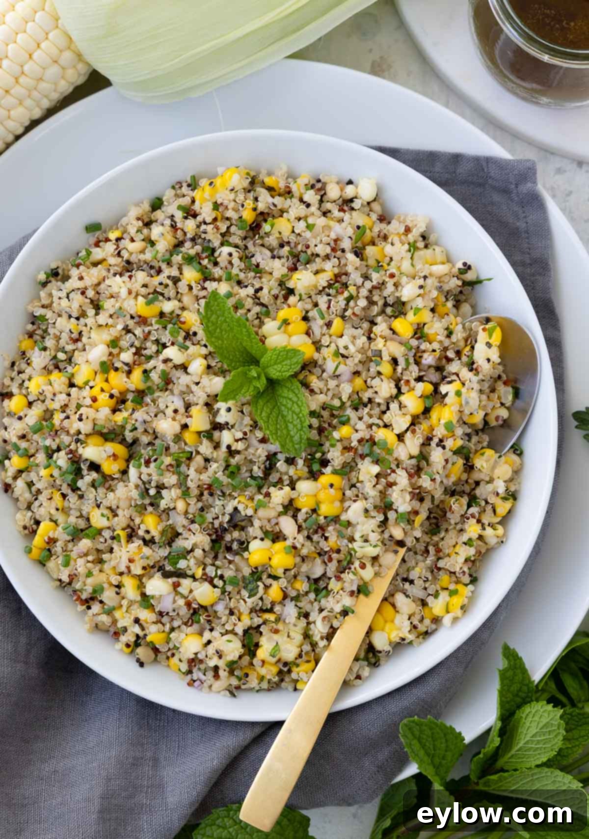 A Corn and quinoa salad with fresh mint garnishing the center of the bowl.