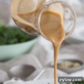 creamy tahini dressing pouring onto salad | AFoodCentricLife.com