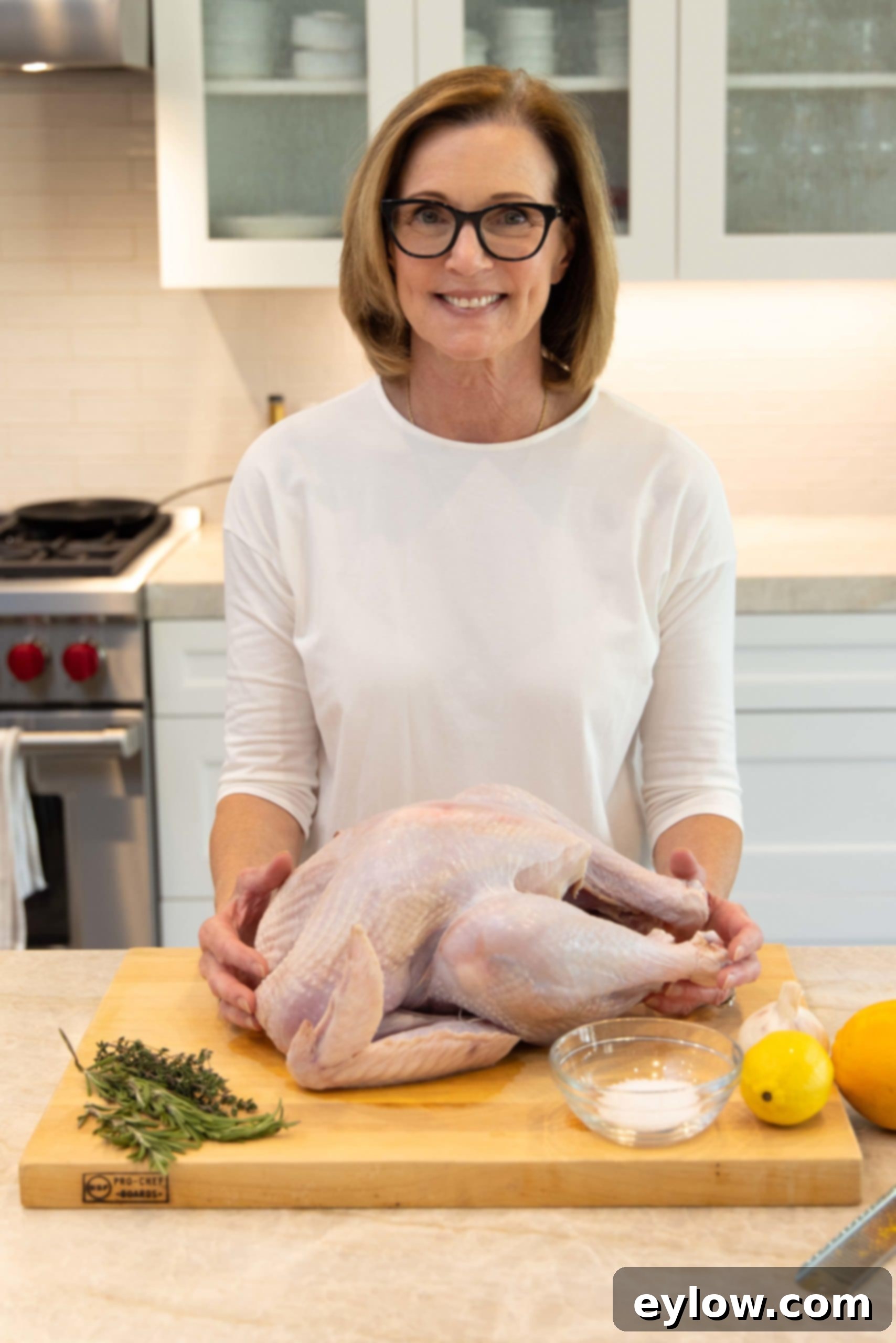 Raw turkey on a cutting board, meticulously prepared and ready to be coated with dry brine ingredients like fresh herbs and citrus.