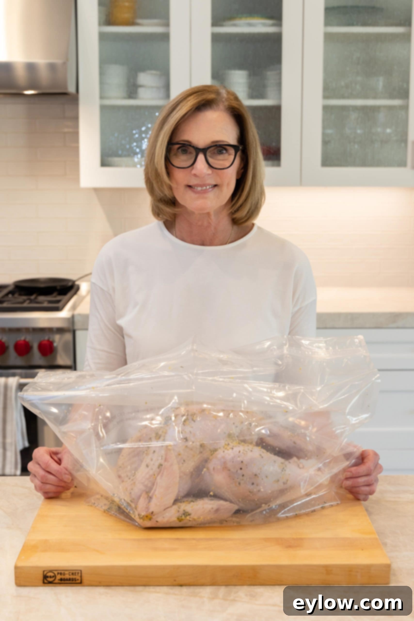 A dry brined turkey placed inside a heavy brining bag on a kitchen counter, with visible herbs, citrus, and salt coating its skin, ready for refrigeration.