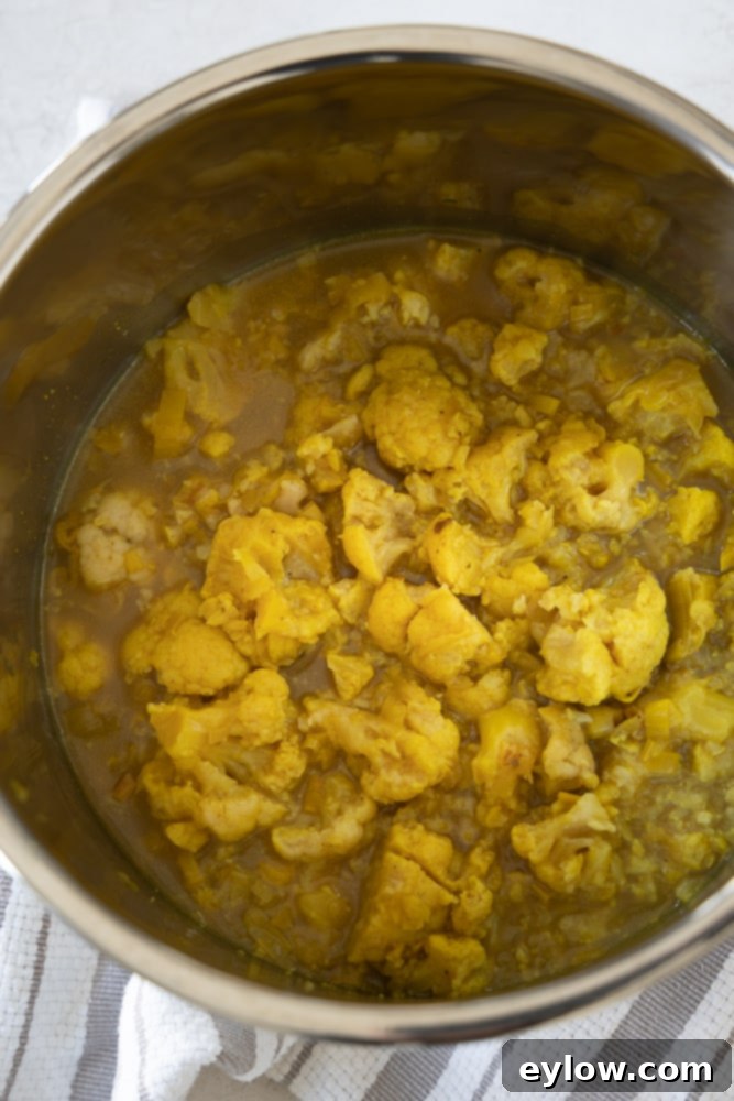 curry cauliflower soup cooking on stovetop | afoodcentriclife.com