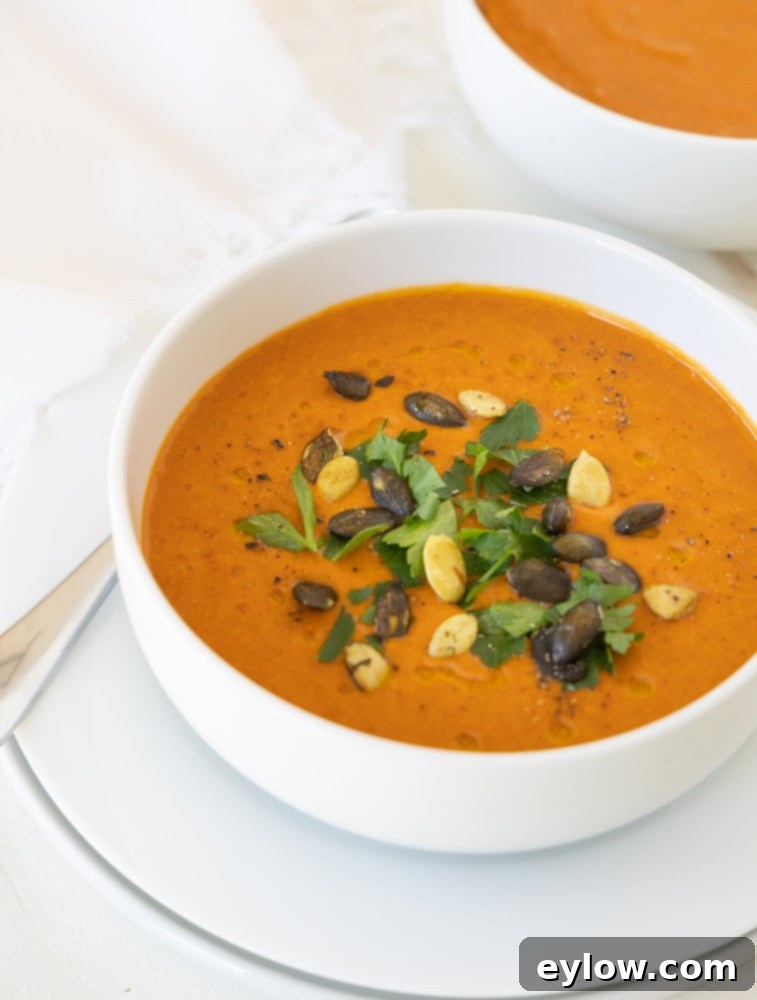 Smoky Sweet Sheet Pan Red Pepper Soup 2 Vibrant roasted red pepper soup ready to serve, garnished with herbs.