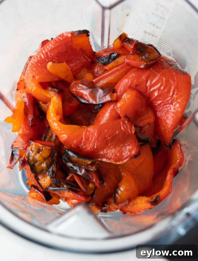Smoky Sweet Sheet Pan Red Pepper Soup 3 Close-up of roasted peppers and garlic in a blender, ready for pureeing.