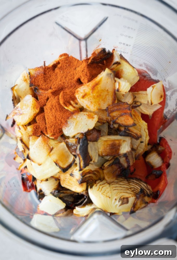 Smoky Sweet Sheet Pan Red Pepper Soup 4 A bowl of creamy roasted red pepper soup, garnished and ready to eat.