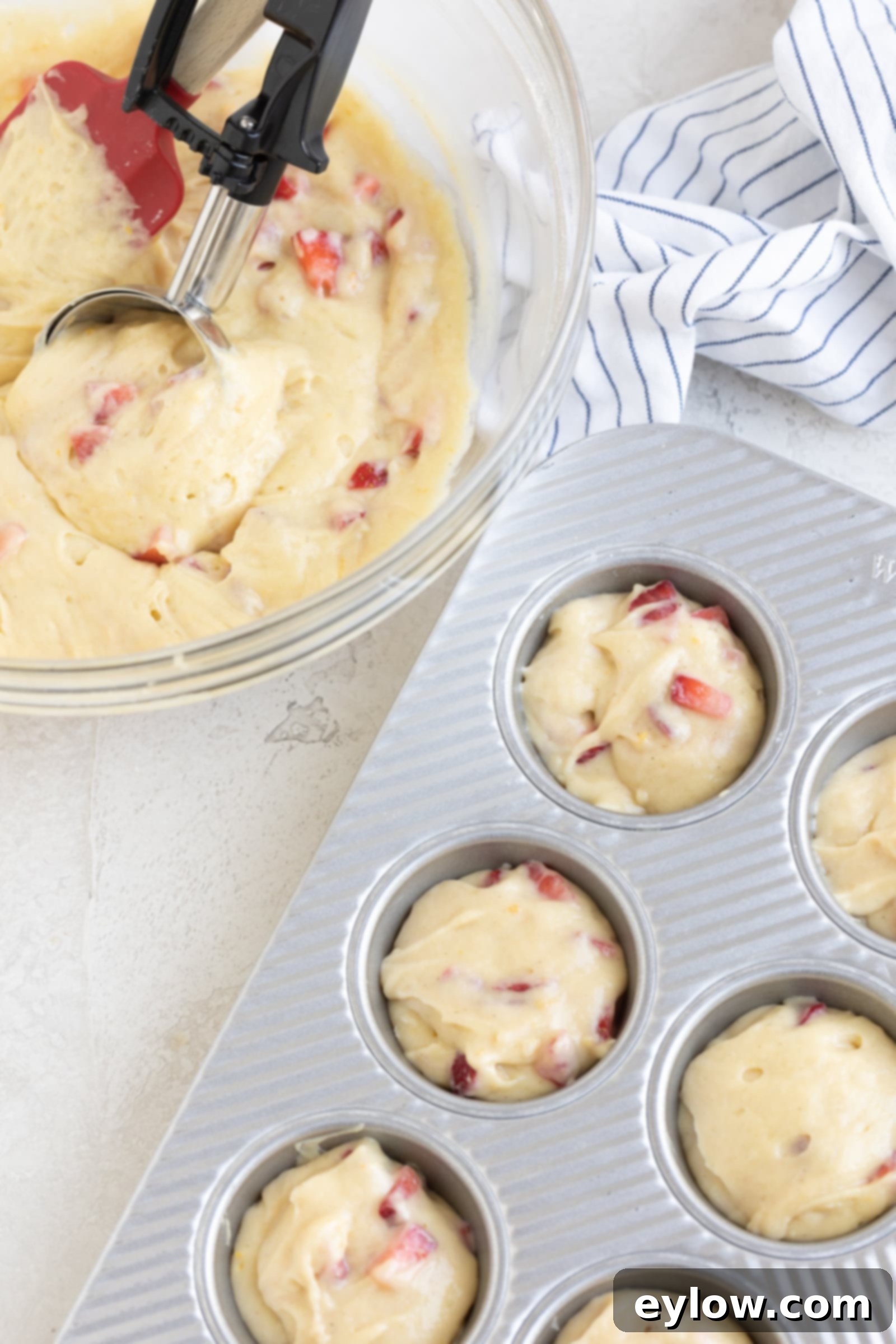 Fluffy Gluten-Free Strawberry Muffins 5 Portioning the batter into a baking muffin tray with a scooper.