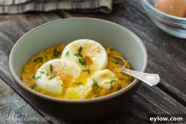 Golden Cheesy Polenta with Poached Eggs 6 A single blue bowl of creamy polenta topped with two perfectly poached eggs and fresh herbs.
