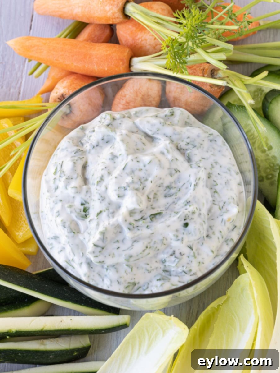 Effortless Green Goddess Dip and Dressing 5 Creamy green goddess dip flecked with lots of green herbs surrounded by raw vegetables for dipping.