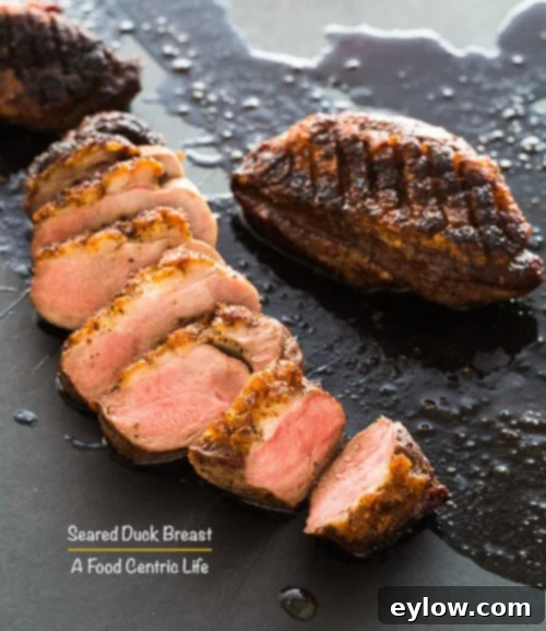 Perfectly Sliced Seared Duck Breast on a wooden cutting board, ready to serve.