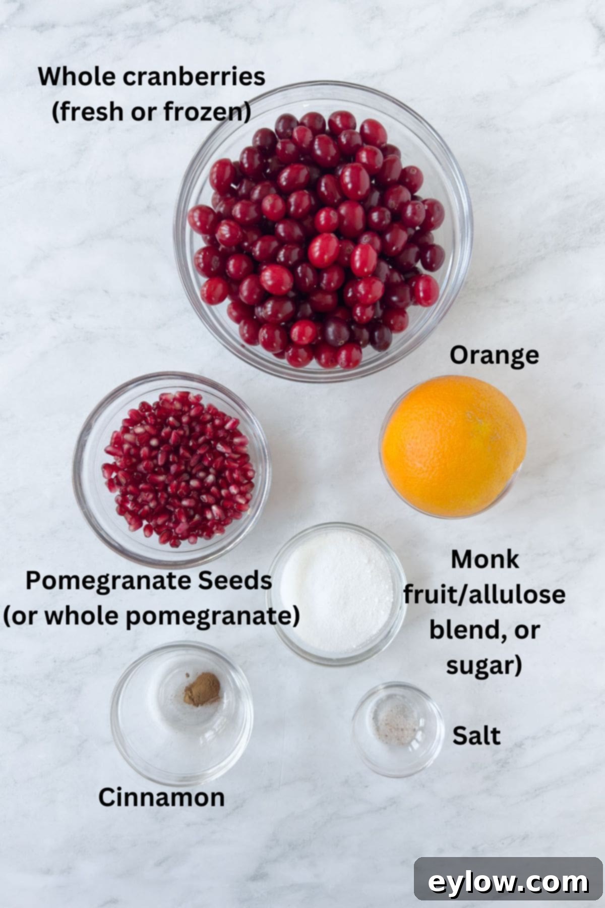 Artisan Whole Berry Cranberry Sauce 3 Ingredients for whole berry cranberry sauce prepped in bowls ready to cook including fresh cranberries, orange, pomegranate seeds, and sweetener.