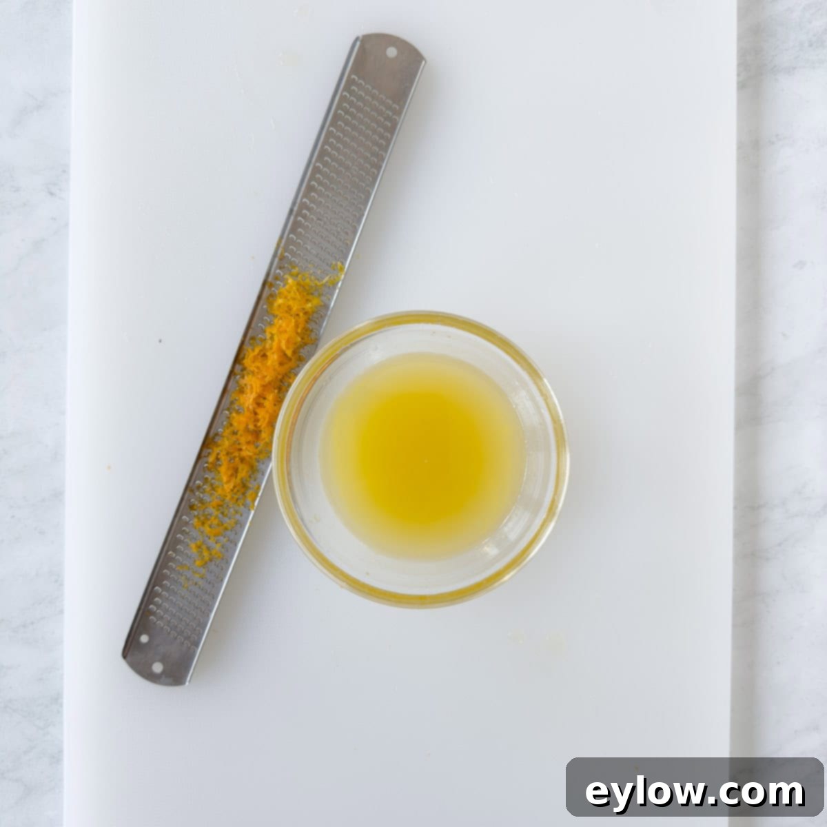 Artisan Whole Berry Cranberry Sauce 4 A microplane zester with orange zest and a small bowl of orange juice, essential steps for preparing whole berry cranberry sauce.