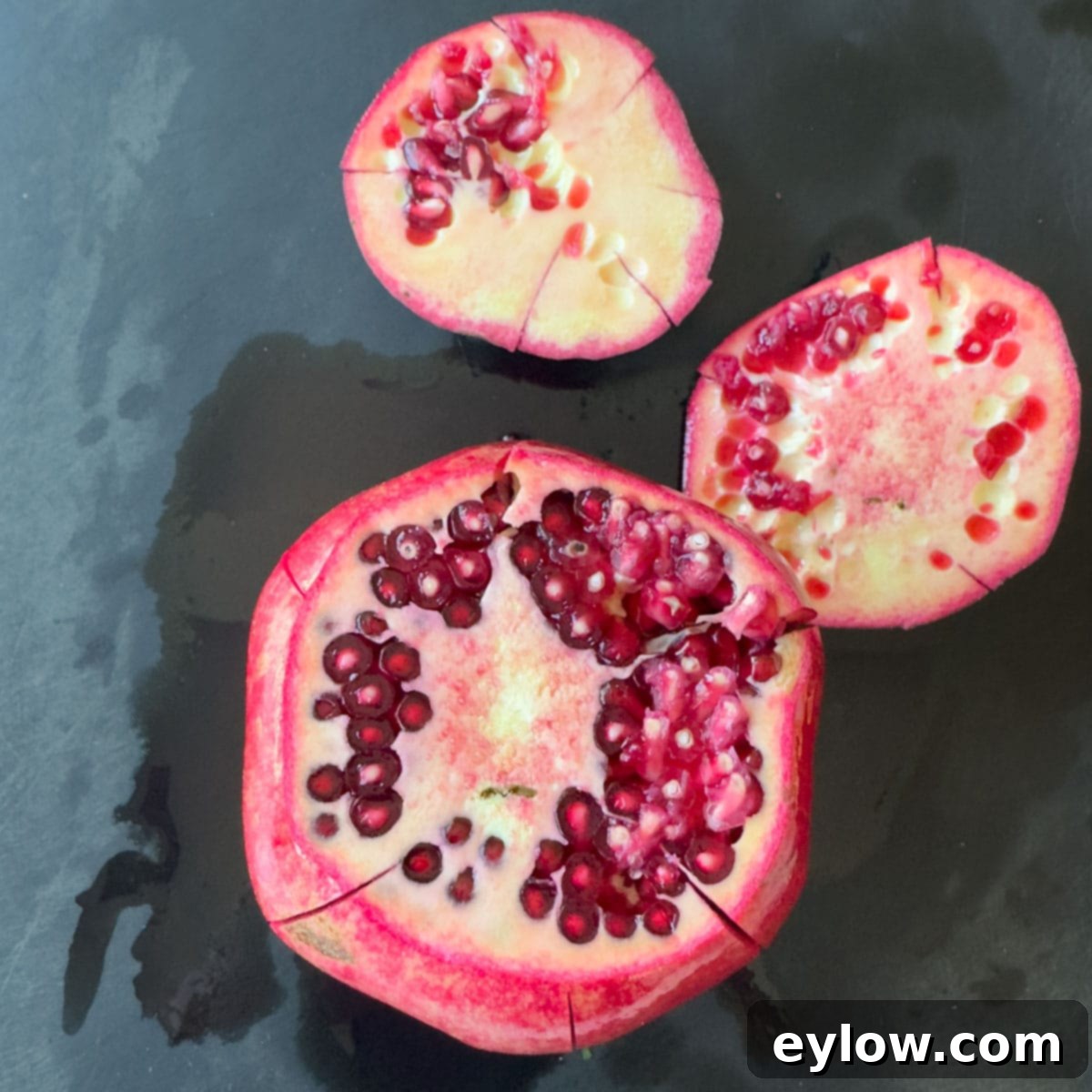 Artisan Whole Berry Cranberry Sauce 9 Whole red pomegranate with the top and bottom end cut off revealing the interior, a crucial step for mess-free pomegranate seeding.