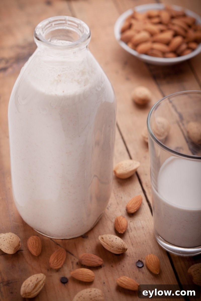 Glass dairy bottle of creamy homemade almond milk with a glass of milk on the side.