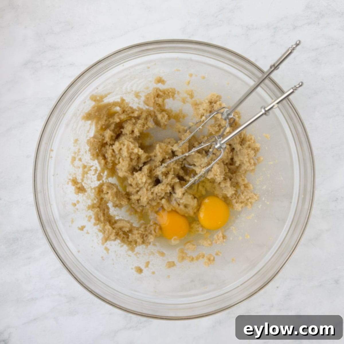 Homemade Cranberry Oatmeal Cookie Bliss 6 Creamed cookie dough with added eggs and beaters in a glass bowl.