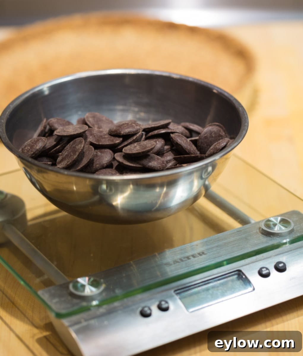Weighing chocolate discs on a glass top digital kitchen scale.