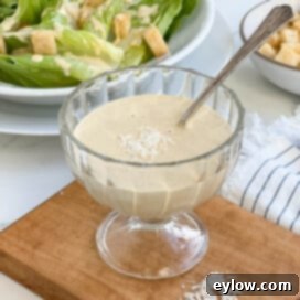 Caesar Dressing No Anchovies Needed 9 A bowl of homemade caesar dressing with spoon.