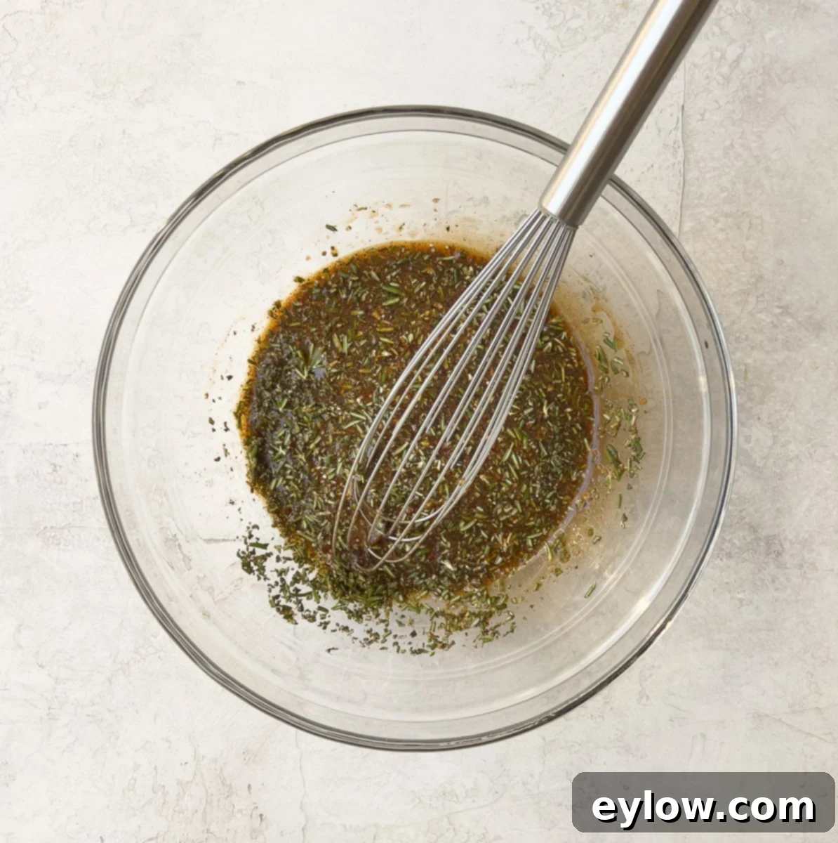 Maple Glazed Sweet and Spicy Cashews 4 Maple spice mix for cashews. A bowl containing a dark, syrupy mixture of maple syrup, spices, and finely chopped rosemary.