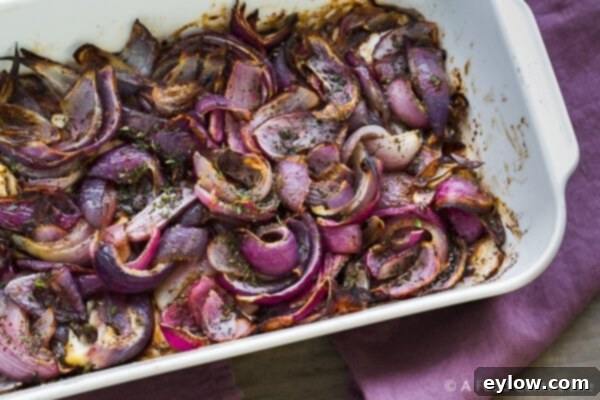 A baking dish filled with roasted red onions, showcasing their deep caramelized color and soft texture, ready to be served.