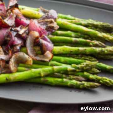 Balsamic glazed red onions with fresh thyme in a white baking dish, ready to be served as a side dish.