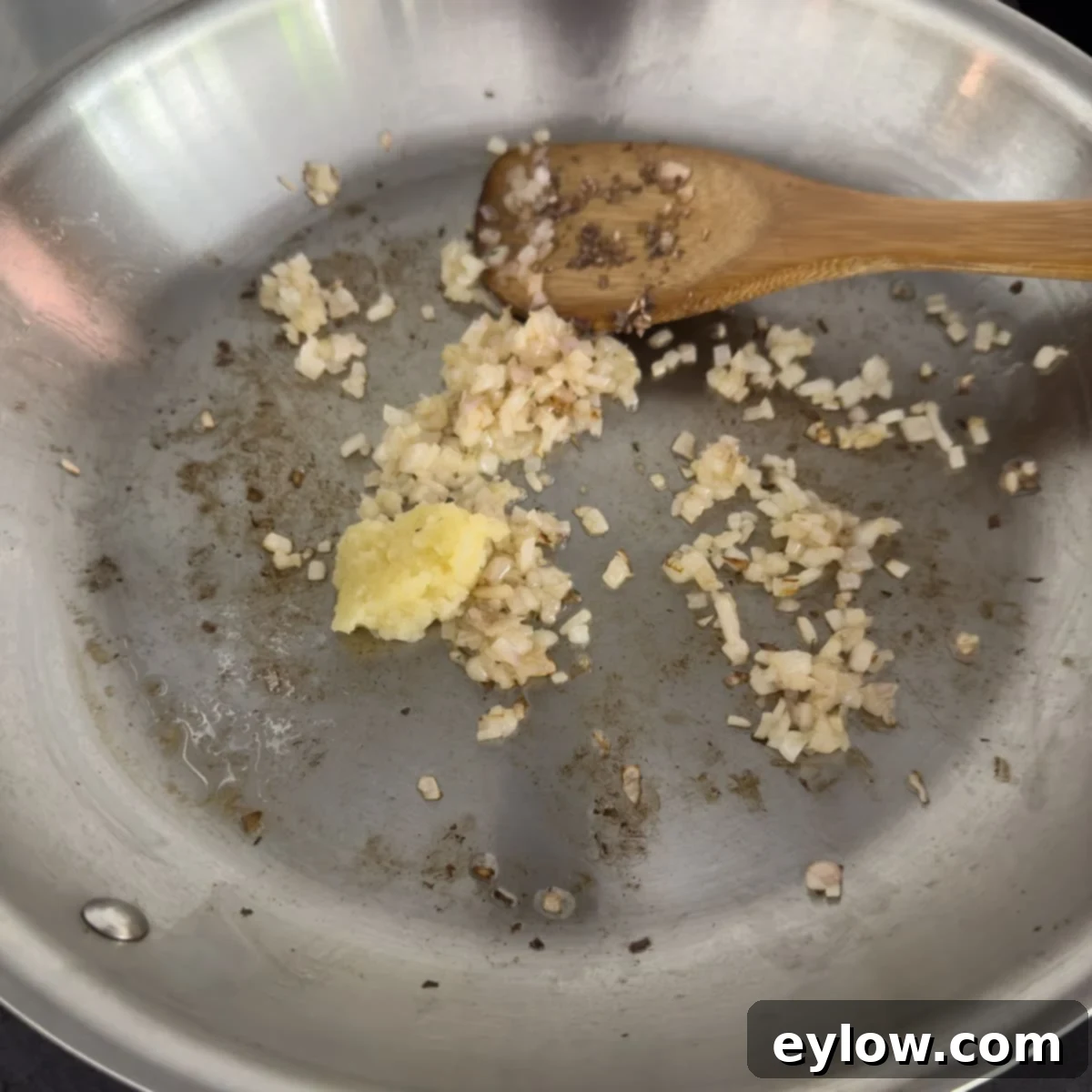 Cooking chopped shallots and garlic in melted butter in a skillet.