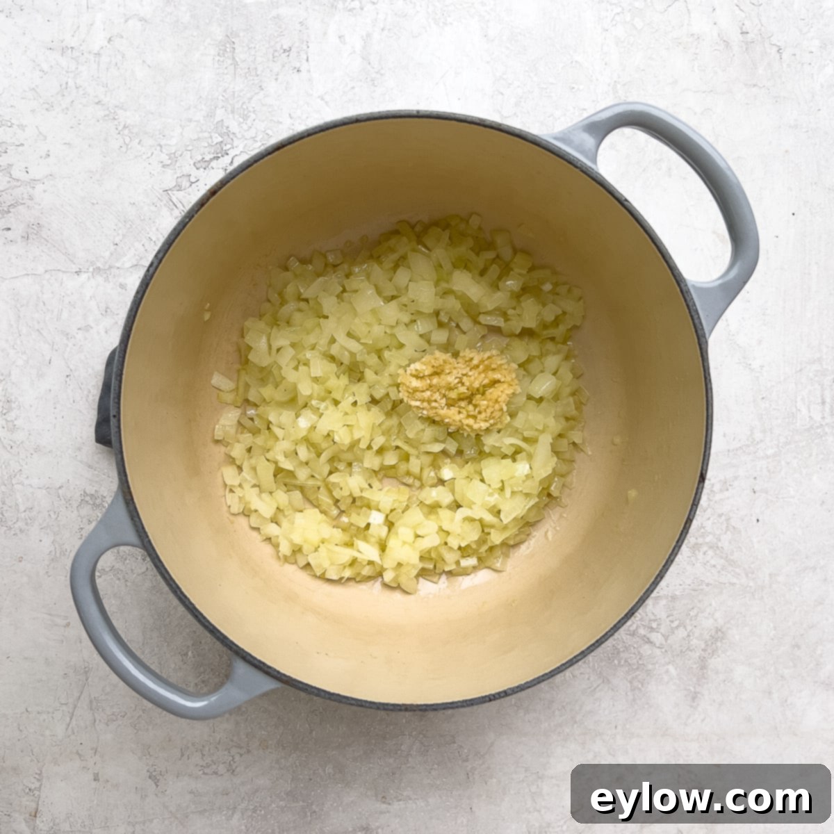 Cooking finely chopped onions and minced garlic in olive oil in a Dutch oven until softened.